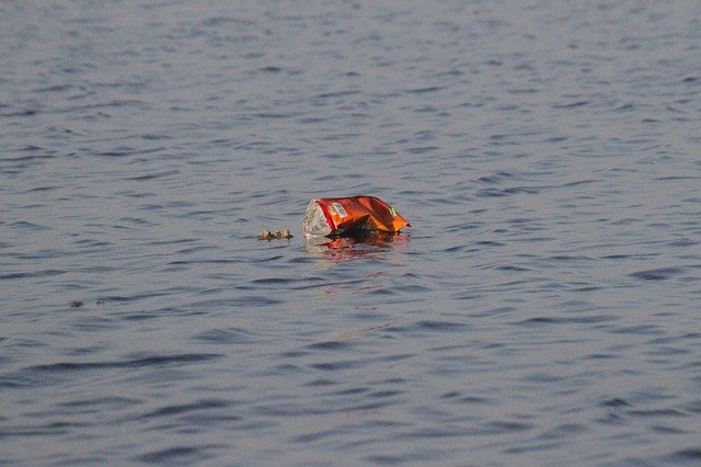 A soda can floating on the surface of the ocean